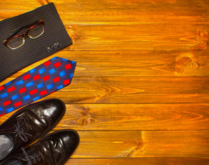 The elegant male set: men's shoes, suit, tie on wooden background.