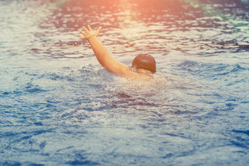 boy playing and swimming in swimming pool ; feeling joyful with his friend