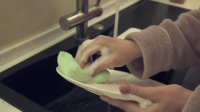 Housewife washing dishes in kitchen slow motion stock footage video