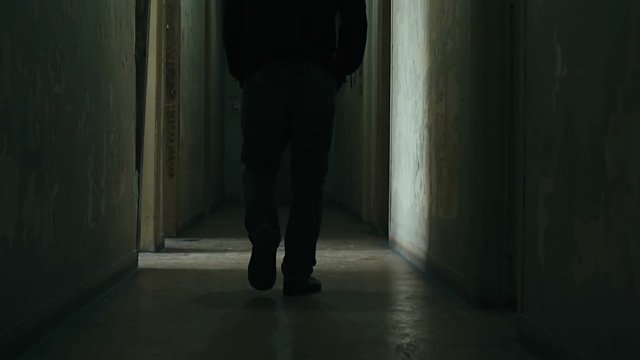 Following a hooded young man inside a dark derelict ghetto building,slow motion dramatic