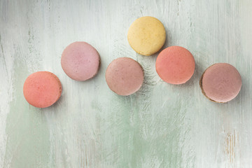 Pastel colored macarons on light teal texture