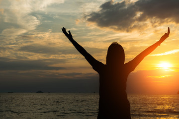 Fototapeta premium Silhouette women hands up on the beash.