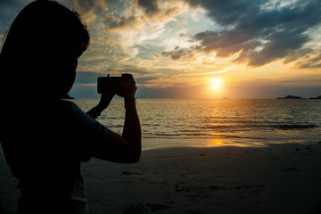 silhuoette women selfie and sunset on the beach seaside.