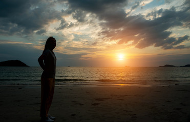 Fototapeta premium Silhouette women watching the sunset at the beach.