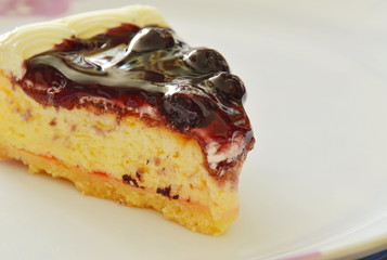 blueberry cheese pie cut for piece on white plate