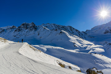 Fototapeta na wymiar Ski winter season, ski run in Italian Alps. Solda with Ortler, Zebru, Grand Zebru in background. Val Venosta, South Tirol, Italy.