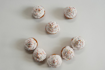 Cupcakes with white cream and sprinkles