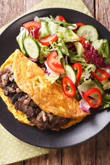 Austrian cuisine: Imperial cutlet with mushrooms, scrambled eggs and fresh salad closeup. vertical top view