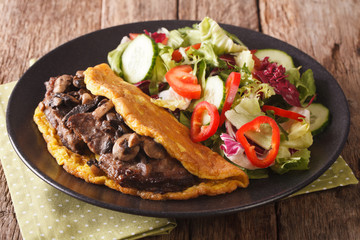 Austrian cutlet with mushrooms, scrambled eggs and vegetable salad close-up. horizontal