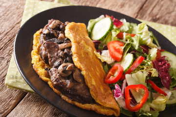 Imperial cutlet with mushrooms, scrambled eggs and vegetable salad close-up. horizontal