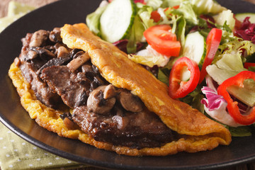 Imperial beef steak with mushrooms, scrambled eggs and vegetable salad close-up. horizontal