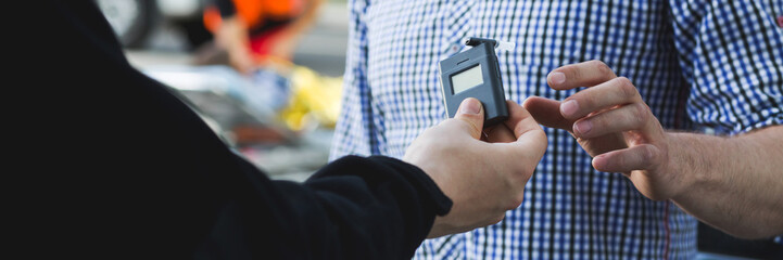 Policeman giving a breathalyzer to a driver