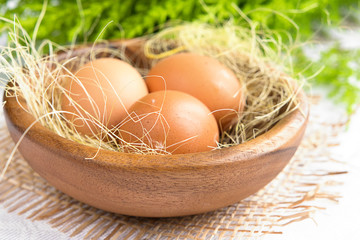 Chicken eggs in wooden plate closeup in rustic style