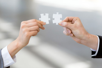 man and woman hand holding jigsaw puzzles