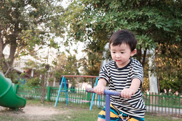 Happy kid play teeter totter in playground, color tone, shallow Focus.