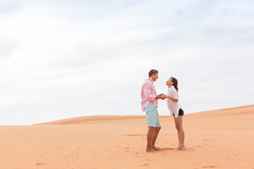 Fototapeta na wymiar Young Man Woman In Desert Beautiful Couple Asian Girl And Guy Hold Hands Sand Dune Landscape Background