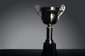 shot of gold award trophy in gray background