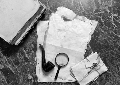 papers and book on detective work table with tools