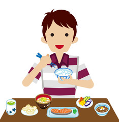 和食の朝食を食べる若い男性