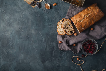 Baked cake with dried fruits and nuts on rustic background. Top view with copy space.