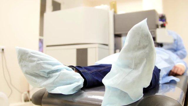 The patient on the operating table - surgery room, legs in medical shoe covers, close up