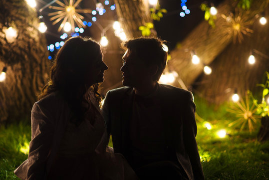 wedding couple in magical night forest decorated light garlands silhouette