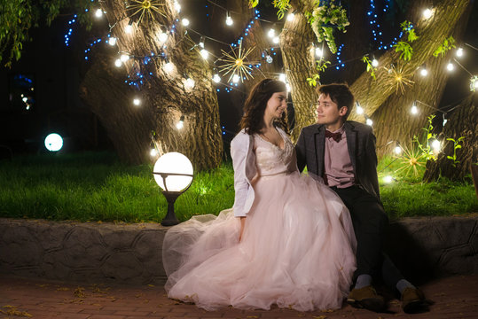 wedding couple in magical night forest decorated light garlands