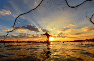 Silluate fisherman and boat in river on during sunset,Thailand