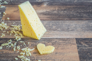 Cheese on the wooden table in the kitchen. Dairy product. Healthy eating and lifestyle.