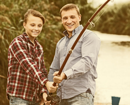 Father And Son Fishing On River