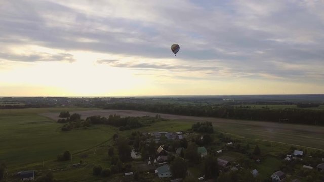 Red balloon in the shape of a heart.Aerial view:Hot air balloon in the sky over a field in the countryside,beautiful sky and sunset. 4K video,ultra HD.