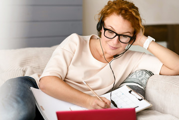 Involved charming woman studying languages at home