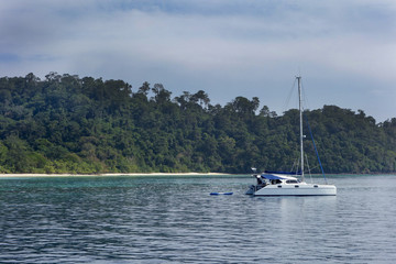 Fototapeta na wymiar Excursion modern luxury motor boat catamaran near the coastline of beautiful lagoon with azure water at summer sunny day
