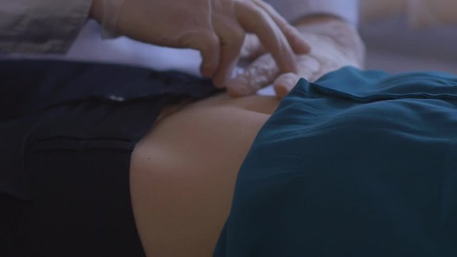 doctor palpates the abdomen patient in his office