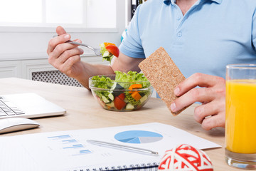 Unrecognizable man has healthy business lunch in modern office interior