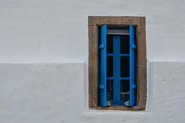 A blue window on a white wall. The colours that dominate in greek islands. So simple but so beautiful.