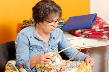 woman sewing for finish a quilt.