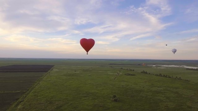 Aerial view:Hot air balloon in the sky over a field in the countryside in the beautiful sky and sunset.Aerostat fly on the countryside. 4K video,ultra HD.