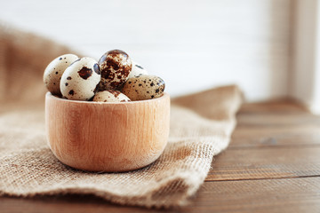 A wooden bowl of quail eggs on the table. The concept of healthy eating and vegetarianism.