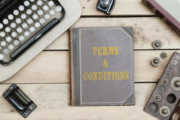 Terms and Conditions on old book cover at office desk with vintage items © MichaelJBerlin