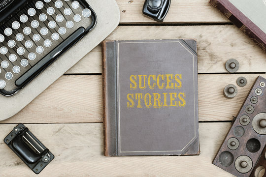 Success Stories On Old Book Cover At Office Desk With Vintage Items