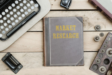 Market Research on old book cover at office desk with vintage items © MichaelJBerlin