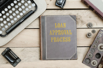 Loan Approval Process on old book cover at office desk with vintage items © MichaelJBerlin
