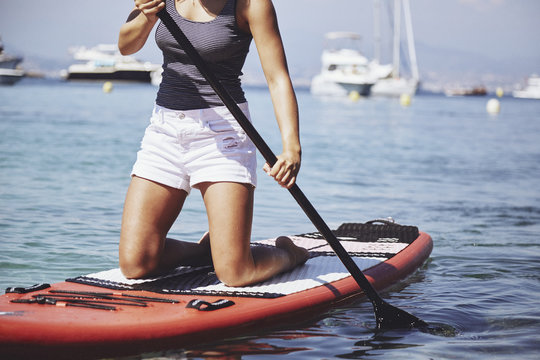 Girl kneeling on a paddle board