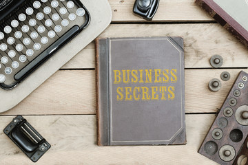Business Secrets on old book cover at office desk with vintage items © MichaelJBerlin