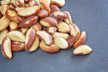 Close up picture of Brazil nuts on dark slate background