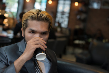 Businessman drinking coffee in the city cafe during lunch time.