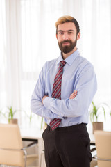 Happy businessman standing in boardroom