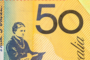 Australian 50 dollar bill fragment closeup showing the number fifty on yellow background.