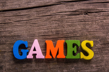 games word made from colored wooden letters on an old table. Concept